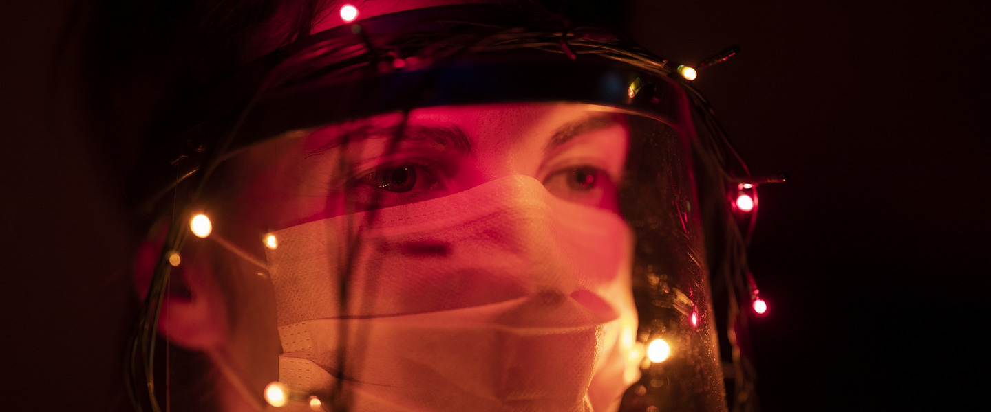 Photo of a person wearing a mask and fairy lights